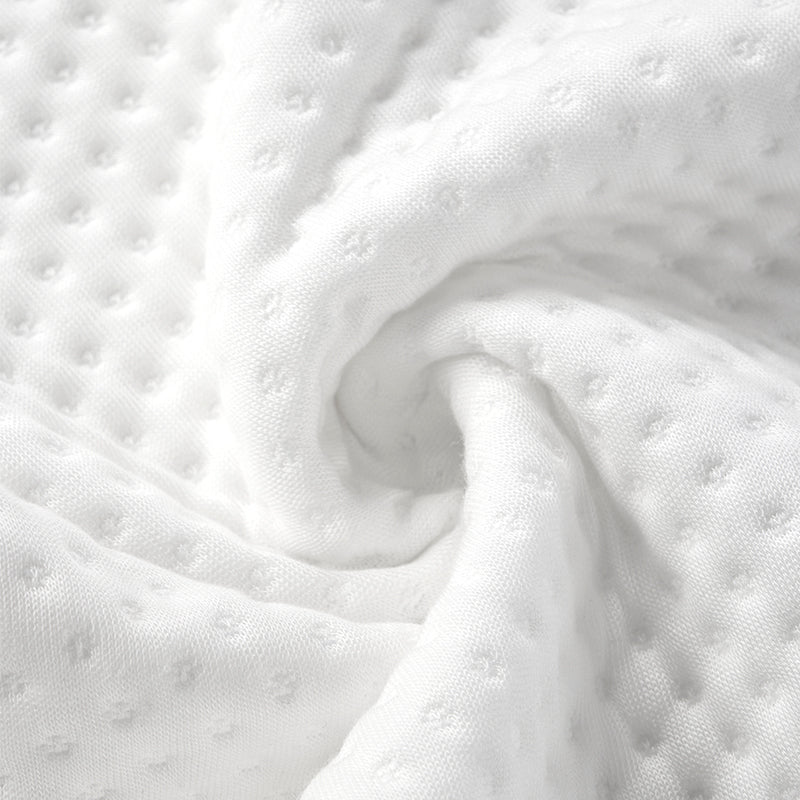 Close-up of soft, breathable white fabric with a textured dot pattern, ideal for ergonomic sleep products.